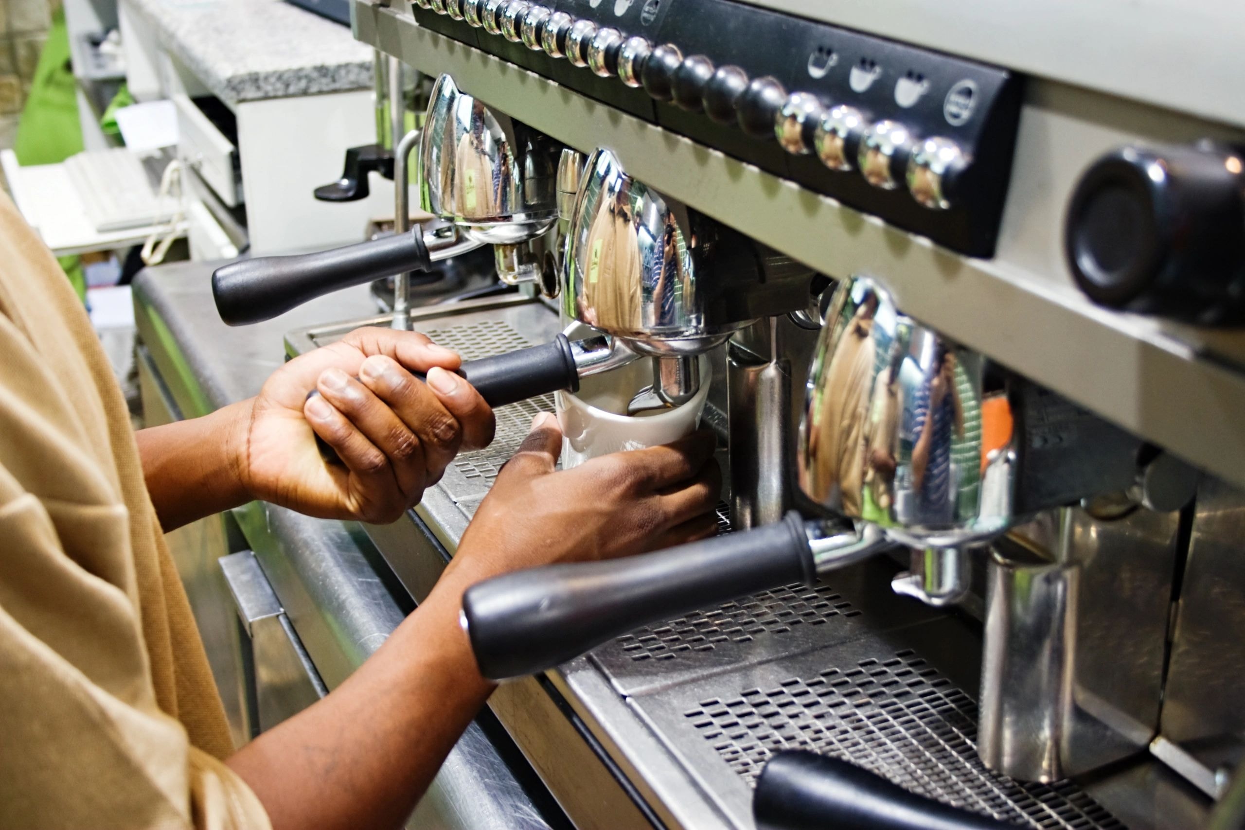 Barista hands operating espresso machine